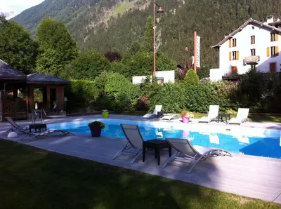 a swimming pool with a bunch of chairs around it at Oustalet in Chamonix-Mont-Blanc