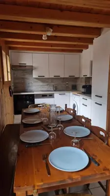 a wooden table with plates on it in a kitchen at Demi-Chalet Le Bief --Prox pistes in Les Carroz d'Araches
