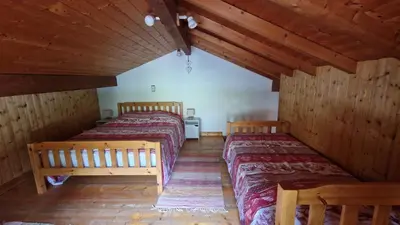 two beds in a room with wooden walls at Demi-Chalet Le Bief --Prox pistes in Les Carroz d'Araches