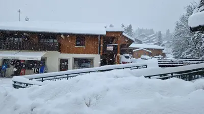 a building covered in snow in front of a building at Appartement L'Ecureuil 8 pers -Prox pistes et centre village- in Les Carroz d'Araches