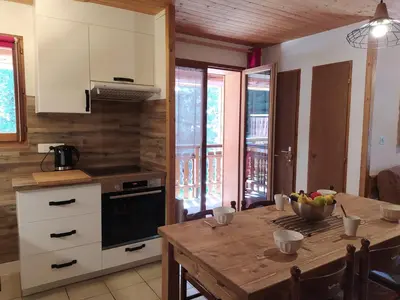 a kitchen with a table with a bowl of fruit on it at Appartement L'Ecureuil 8 pers -Prox pistes et centre village- in Les Carroz d'Araches