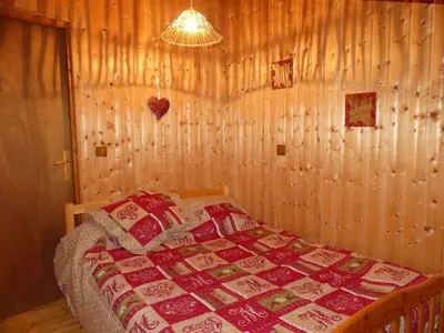 a bedroom with a bed with a quilt on it at Demi-Chalet l'Ancolie -- Prox pistes in Les Carroz d'Araches