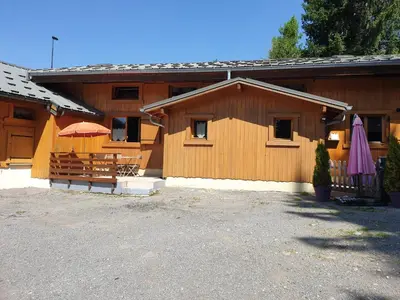a building with tables and umbrellas in front of it at Demi-Chalet l'Ancolie -- Prox pistes in Les Carroz d'Araches