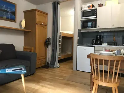 a small living room with a couch and a kitchen at Appartement chamonix face au mont blanc in Chamonix-Mont-Blanc