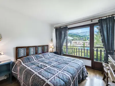 a bedroom with a bed and a large window at Appartement 2 chambres à Megève, proche Palais des Sports - FR-1-453-157 in Megève