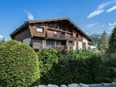 a wooden house with a balcony on top of some bushes at Appartement 2 chambres à Megève, proche Palais des Sports - FR-1-453-157 in Megève