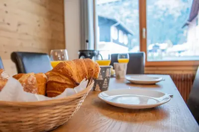 a basket of bread sitting on a wooden table at Mintaka Apartment - Chamonix in Chamonix-Mont-Blanc