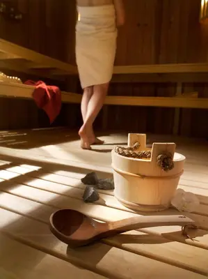 a woman standing in a room with a flower pot and spoons at CGH Résidence Boutique Le Centaure in Flaine
