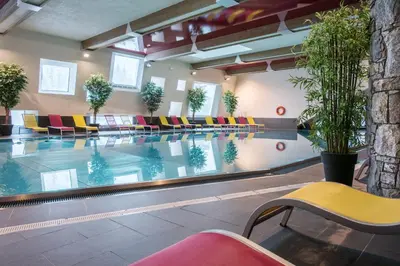 a swimming pool with colorful chairs in a building at CGH Résidence Boutique Le Centaure in Flaine