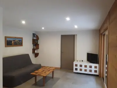 a living room with a couch and a table at Appartement rez de jardin in Saint-Gervais-les-Bains