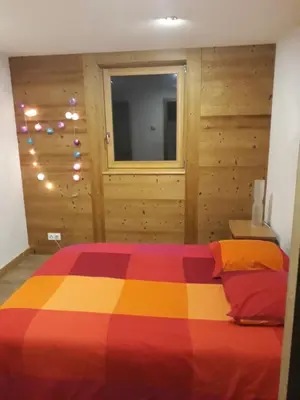 a white building with wooden doors and a staircase at Appartement rez de jardin in Saint-Gervais-les-Bains