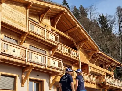 two people standing in front of a wooden building at Chalet Arpitan - les Carroz - Grand Massif in Les Carroz d'Araches