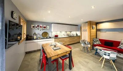 a kitchen and living room with a red couch and a table at Chalet Arpitan - les Carroz - Grand Massif in Les Carroz d'Araches