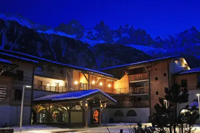 a building with snowy mountains in the background at La Cordee 412 Apartment - Chamonix All Year in Chamonix-Mont-Blanc