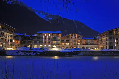 a hotel at night with a mountain in the background at La Cordee 412 Apartment - Chamonix All Year in Chamonix-Mont-Blanc