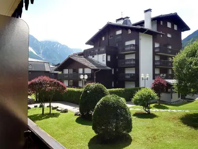 a large apartment building with a yard with bushes at Apartment Clos du Savoy-8 by Interhome in Chamonix-Mont-Blanc