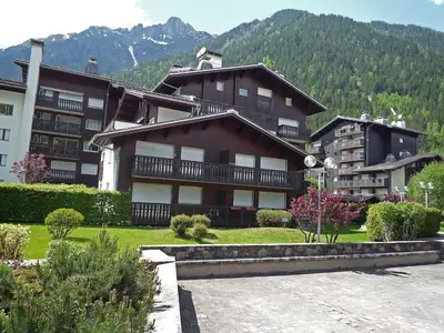 a large building with a mountain in the background at Apartment Clos du Savoy-8 by Interhome in Chamonix-Mont-Blanc