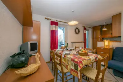 a kitchen and dining room with a table and a television at Résidence Jardins d'Androsace 17 - Happy Rentals in Chamonix-Mont-Blanc