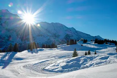 a sun is shining on a snow covered mountain at Résidence Jardins d'Androsace 17 - Happy Rentals in Chamonix-Mont-Blanc