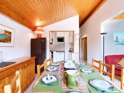 a kitchen with a black refrigerator and white cabinets at Apartment Martagon-1 by Interhome in Saint-Gervais-les-Bains