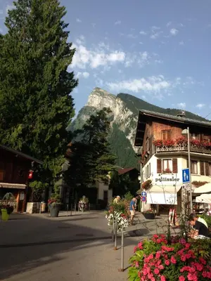 a street with a building and a mountain in the background at ECRINS ETOILE C9 in Samoëns