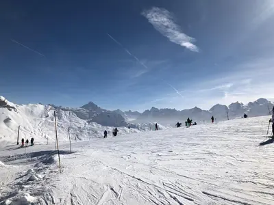 a group of people skiing down a snow covered slope at ECRINS ETOILE C9 in Samoëns