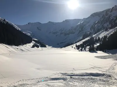 a snow covered mountain with the sun in the background at ECRINS ETOILE C9 in Samoëns