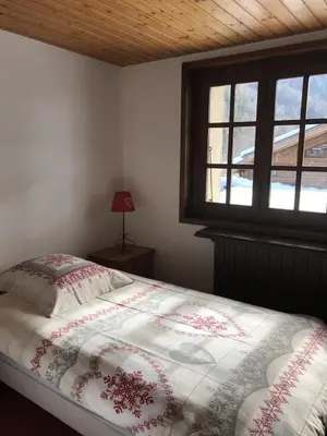 a bedroom with a bed and a window at Grangettes in Les Carroz d'Araches