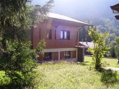 a large wooden house in the middle of a field at Grangettes in Les Carroz d'Araches