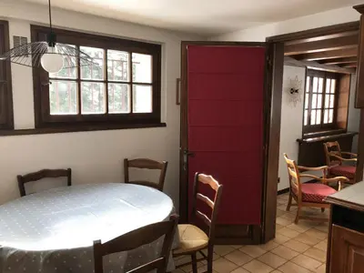 a dining room with a table and a red door at Grangettes in Les Carroz d'Araches