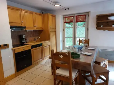 a kitchen with a wooden table with chairs and a tableablish at Apartment Conseil 1 by Interhome in Saint-Gervais-les-Bains