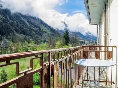a table on a balcony with a view of mountains at Apartment Le Carlton-5 by Interhome in Chamonix-Mont-Blanc