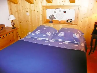a bedroom with a blue bed and a window at Chalet du Bulle by Interhome in Saint-Gervais-les-Bains