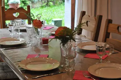 a table with plates and glasses and flowers on it at Thendia Montblanc in Les Houches