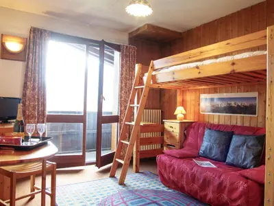a living room with a bunk bed and a red couch at Apartment Les Periades by Interhome in Chamonix-Mont-Blanc