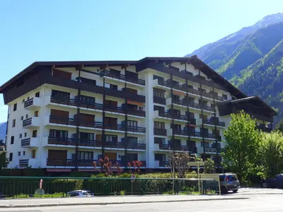 a large white building with a mountain in the background at Apartment Les Periades by Interhome in Chamonix-Mont-Blanc
