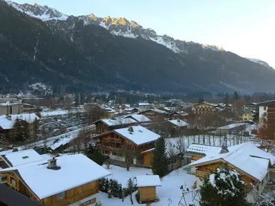 a town covered in snow with mountains in the background at Apartment Les Periades by Interhome in Chamonix-Mont-Blanc