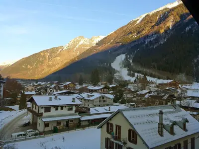 a small town with snow covered roofs and mountains at Apartment Les Periades by Interhome in Chamonix-Mont-Blanc
