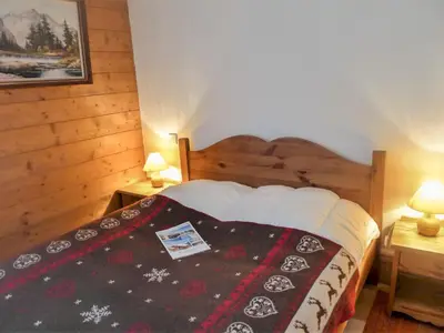 a bedroom with a bed with a blanket and two lamps at Apartment Le Krystor by Interhome in Chamonix-Mont-Blanc