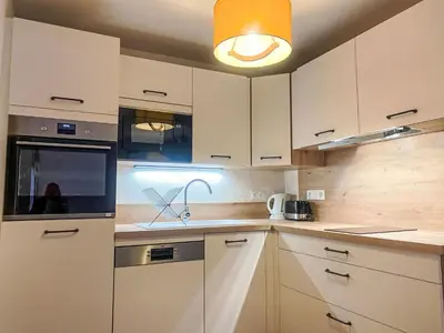 a kitchen with white cabinets and a light fixture at Apartment L'Espace Montagne-11 by Interhome in Chamonix-Mont-Blanc