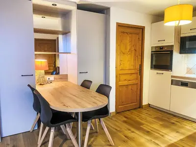 a kitchen and dining room with a wooden table and chairs at Apartment L'Espace Montagne-11 by Interhome in Chamonix-Mont-Blanc
