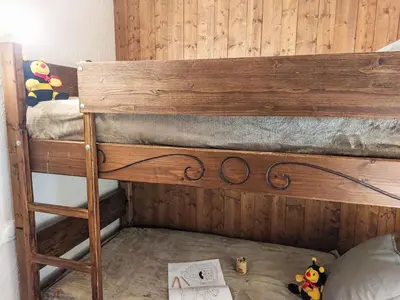 a teddy bear sitting on a bed with a pillow at Apartment Les G'rets-4 by Interhome in Saint-Gervais-les-Bains