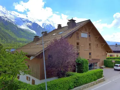 a living room with a red couch and a bed at Apartment Les Pècles by Interhome in Chamonix-Mont-Blanc