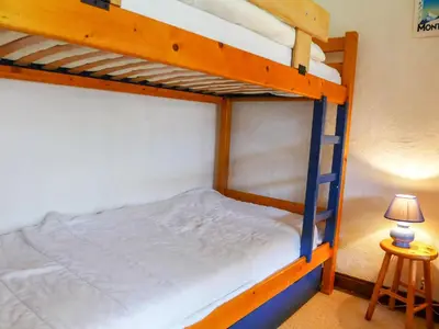 two bunk beds in a room with a lamp at Apartment Les Pècles by Interhome in Chamonix-Mont-Blanc