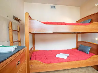 a bedroom with two bunk beds and a chair at Apartment Le Mummery-4 by Interhome in Chamonix-Mont-Blanc