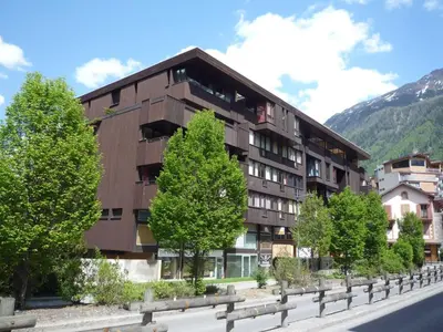 a building with people standing outside of it in the snow at Apartment Le Mummery-4 by Interhome in Chamonix-Mont-Blanc