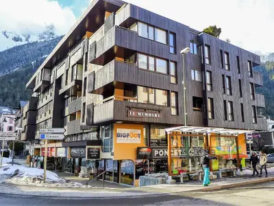 a building with mountains in the background at Apartment Le Mummery-4 by Interhome in Chamonix-Mont-Blanc