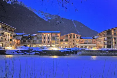a resort with a mountain in the background at night at La Cordée - Charmant Appartement – 4 personnes in Chamonix-Mont-Blanc