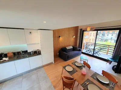 a living room with a dining table and a kitchen at La Cordée - Charmant Appartement – 4 personnes in Chamonix-Mont-Blanc