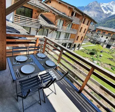 a table and chairs on the balcony of a house at La Cordée - Charmant Appartement – 4 personnes in Chamonix-Mont-Blanc